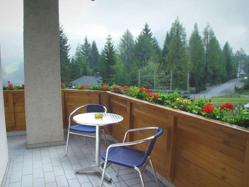 a patio with two chairs and a table on a balcony at Apartment in Hermagor Pressegger See with sauna in Sonnenalpe Nassfeld
