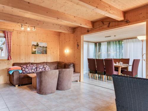 a living room with a couch and a table and chairs at Chalet in St Georgen ob Murau with sauna in Sankt Georgen ob Murau