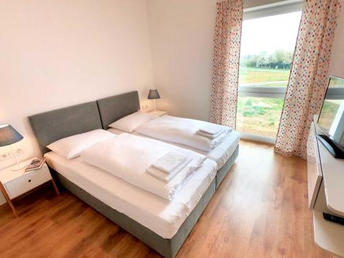 1 cama grande en un dormitorio con ventana grande en Ferienhaus XL en Lutzmannsburg