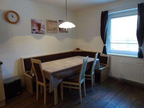 a dining room with a table and chairs and a clock at Apartment at Nassfeld in Carinthia in Sonnenalpe Nassfeld