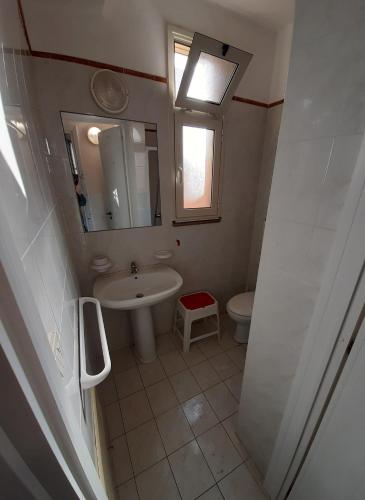 a bathroom with a sink and a mirror and a toilet at Appartamenti 34 Spiaggia di Pescoluse in Marina di Pescoluse