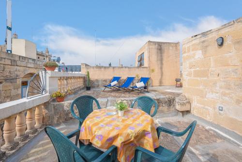 a patio with a table and chairs on a balcony at Casa Melita in Rabat