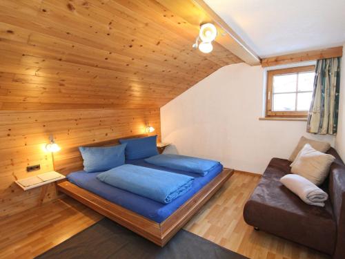 カルテンバッハにあるStunning Apartment in Kaltenbach near Ski Areaのベッドルーム(青いベッド1台、ソファ付)