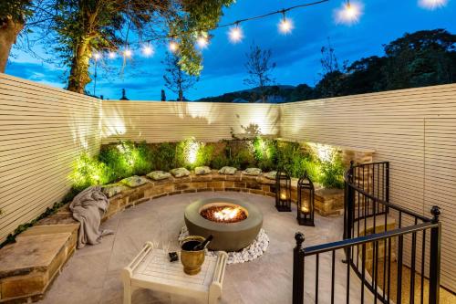 a backyard with a fire pit and a fence with lights at Lower Arthur's Cottage in Saddleworth, Manchester in Oldham