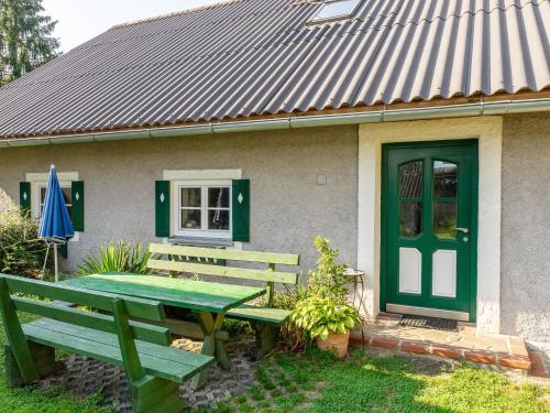 a green table and bench in front of a house at Apartment in Styria near bathing lake in Ligist