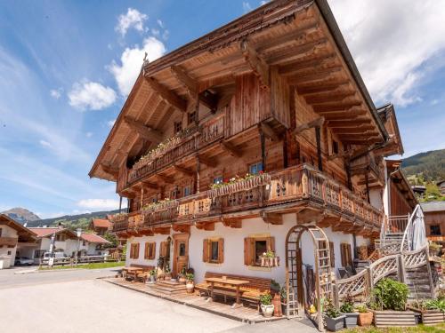 a large wooden house with a balcony at Beautiful flat in Kirchberg near the ski area in Kirchberg in Tirol