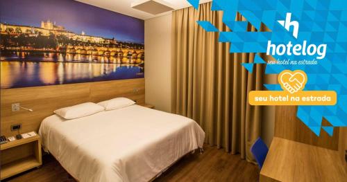 a hotel room with a bed and a picture of a bridge at Hotelog Tibagi in Ponta Grossa