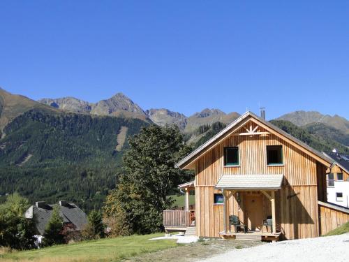a wooden house on a hill with mountains in the background at Chalet in Hohentauern near ski area in Hohentauern