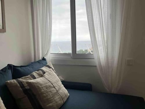 un sofá sentado frente a una ventana con vistas en Apartamento en Playa de Pals con encanto y vistas, en Pals