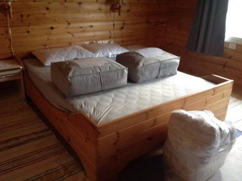 a wooden bed with two pillows on top of it at Å i Lofoten in Moskenes