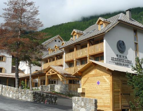 un gran complejo con una montaña en el fondo en Le Grand Aigle Hotel & Spa**** en La Salle Les Alpes