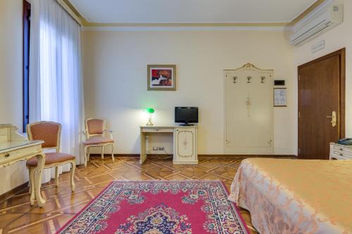 a bedroom with a bed and a desk and a tv at Hotel Marte in Venice