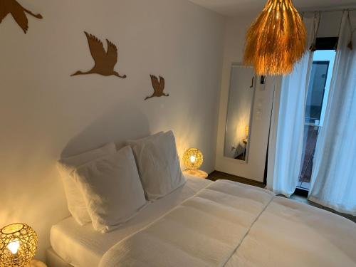 a bedroom with a bed with birds on the wall at Le patio d'Oscar in Failly