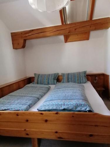 ゾントホーフェンにあるFerienwohnung Soyerの木製のベッドフレームが備わるドミトリールームのベッド1台分です。