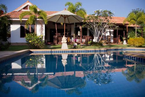 a house with a swimming pool in front of a house at Banburi Villa - 4 Bedroom Private Pool Villa in Krabi