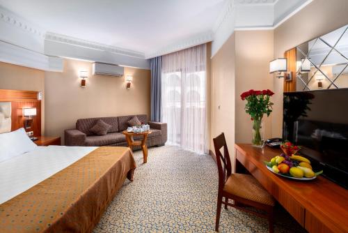 a hotel room with a bed and a table with a bowl of fruit at Bera Alanya Hotel - Halal All Inclusive in Konaklı