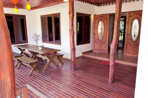 a room with a wooden table and a wooden floor at Banburi Villa - 4 Bedroom Private Pool Villa in Krabi