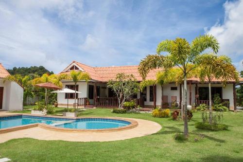 a house with a swimming pool and a yard at Banburi Villa - 4 Bedroom Private Pool Villa in Krabi