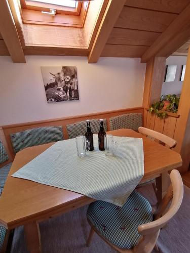 a wooden table with two bottles and two chairs at Ferienwohnung Soyer in Sonthofen