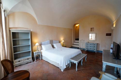 a bedroom with a white bed and a television at Dormiusa in Bordighera
