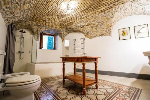 a bathroom with a toilet and a wooden table at Dormiusa in Bordighera