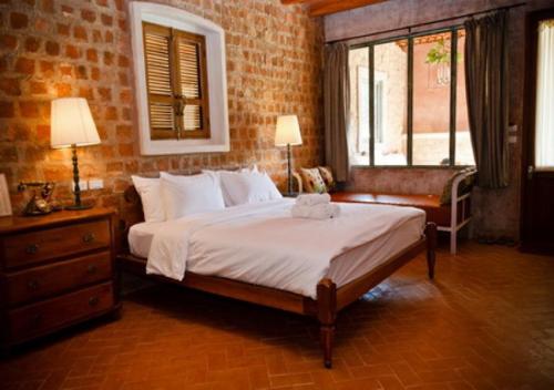 a bedroom with a large bed and a window at La Toscana in Suan Phung