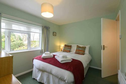 a bedroom with a bed with towels on it at Waterwitch Cottage in Newquay