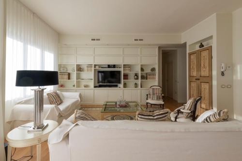sala de estar con sofá blanco y TV en Casa Gramsci luxury apartment en Pesaro