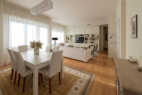 a dining room and living room with a white table and chairs at Casa Gramsci luxury apartment in Pesaro