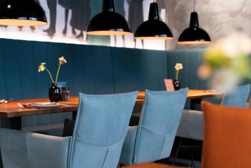 a dining room with a wooden table and chairs at Unsöld's Factory Hotel in Munich
