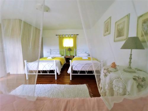 a bedroom with two beds and a lamp in it at Villas and apartments on a private farm, only 1 km away from the beach! in Lefkogeia
