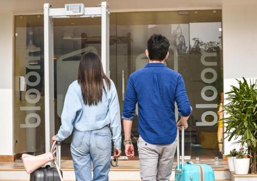 a man and woman walking into a store with luggage at Bloom - Golf Course Road in Gurgaon