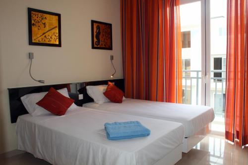 2 camas individuales en una habitación con ventana en Atlantis Lodge, en Marsalforn