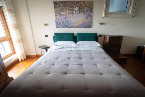 a large bed in a bedroom with a painting on the wall at Residenza San Flaviano, Relais di Charme in LʼAquila