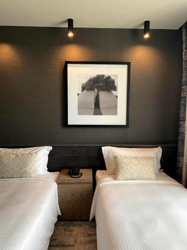 a bedroom with two beds and a picture on the wall at Somerset Westview Nairobi in Nairobi