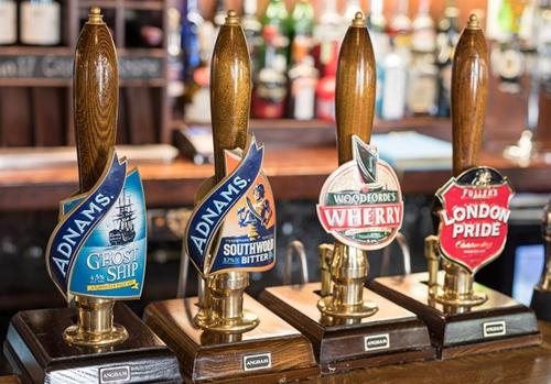 una fila de premios de cerveza en un bar en The Red Lion Eaton en Norwich