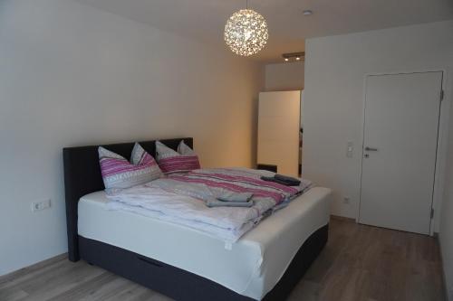 a bedroom with a bed with pink and white pillows at Gartenappartement Leonsberg in Bad Ischl