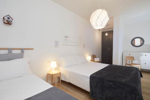 a bedroom with two beds and a pendant light at Casa Morellato in Riva del Garda