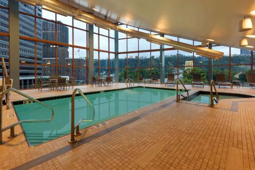 a large swimming pool in a building with windows at Wyndham Grand Pittsburgh in Pittsburgh