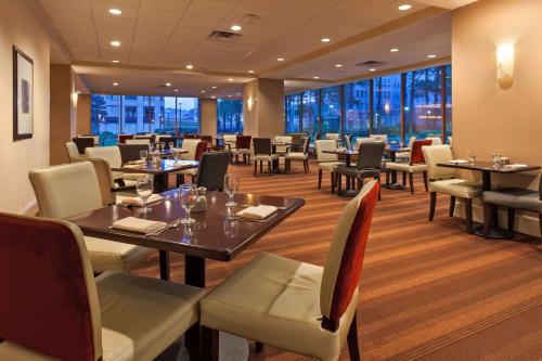 un restaurante con mesas, sillas y ventanas en Wyndham Grand Pittsburgh, en Pittsburgh