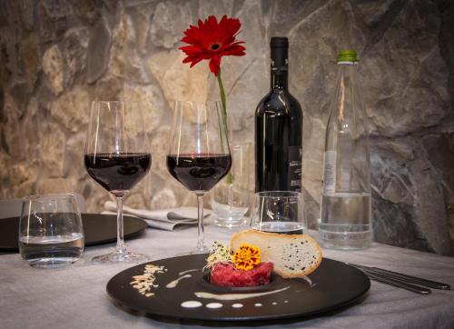 a table with two glasses of wine and a plate of food at Isola Verde Resort in Castiglione del Lago