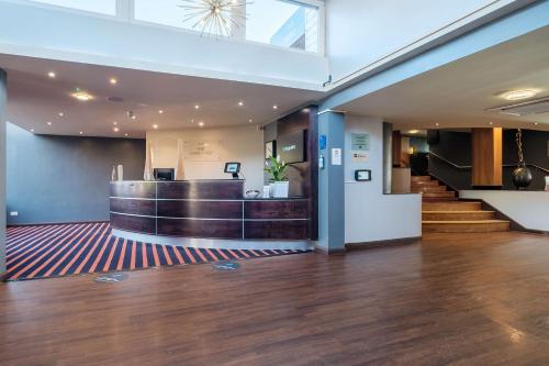 eine Lobby mit einer Bar und Treppen in einem Gebäude in der Unterkunft Hull Humber View Hotel, BW Signature Collection in Hull