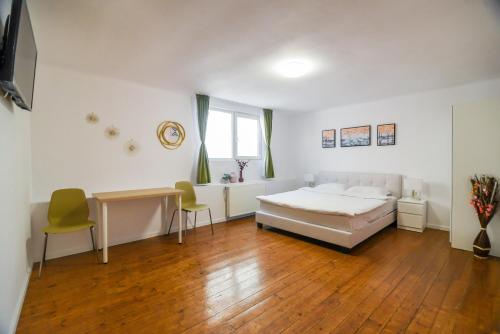 1 dormitorio con 1 cama, mesa y sillas en Transylvania Guest House, en Brasov