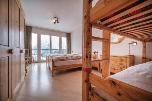 1 Schlafzimmer mit 2 Betten und einem großen Fenster in der Unterkunft Bristol 41 Ferienwohnung im Herzen von Arosa in Arosa