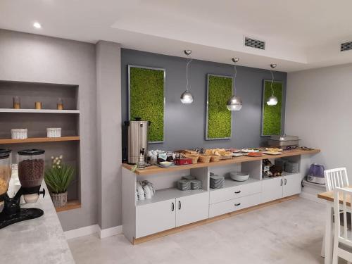 a kitchen with white cabinets and two windows at Fotex in Ząbki