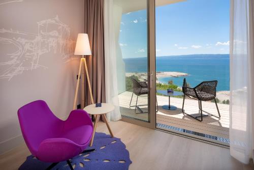 a room with a purple chair and a view of the ocean at Radisson Blu Resort & Spa in Split
