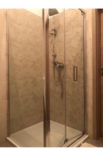 a shower with a glass door in a bathroom at Beach front Paradise Apartment in Sukošan
