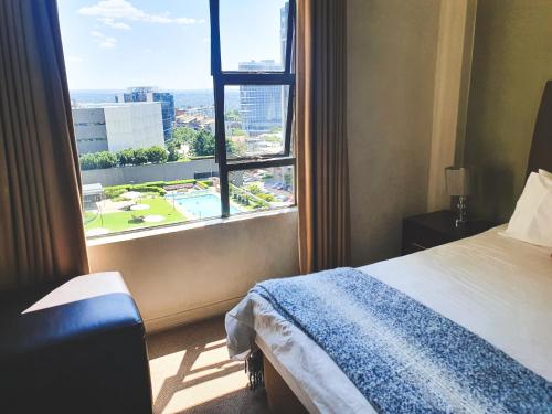 a hotel room with a bed and a large window at Westpoint Sandton Apartments in Johannesburg