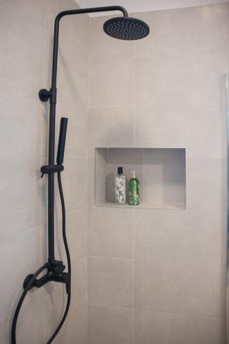 a shower with a shower head in a bathroom at Evgoro - Infinite View in Tsoútsouros