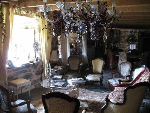 a living room with chairs and a chandelier at Le Francillon in Les Estables